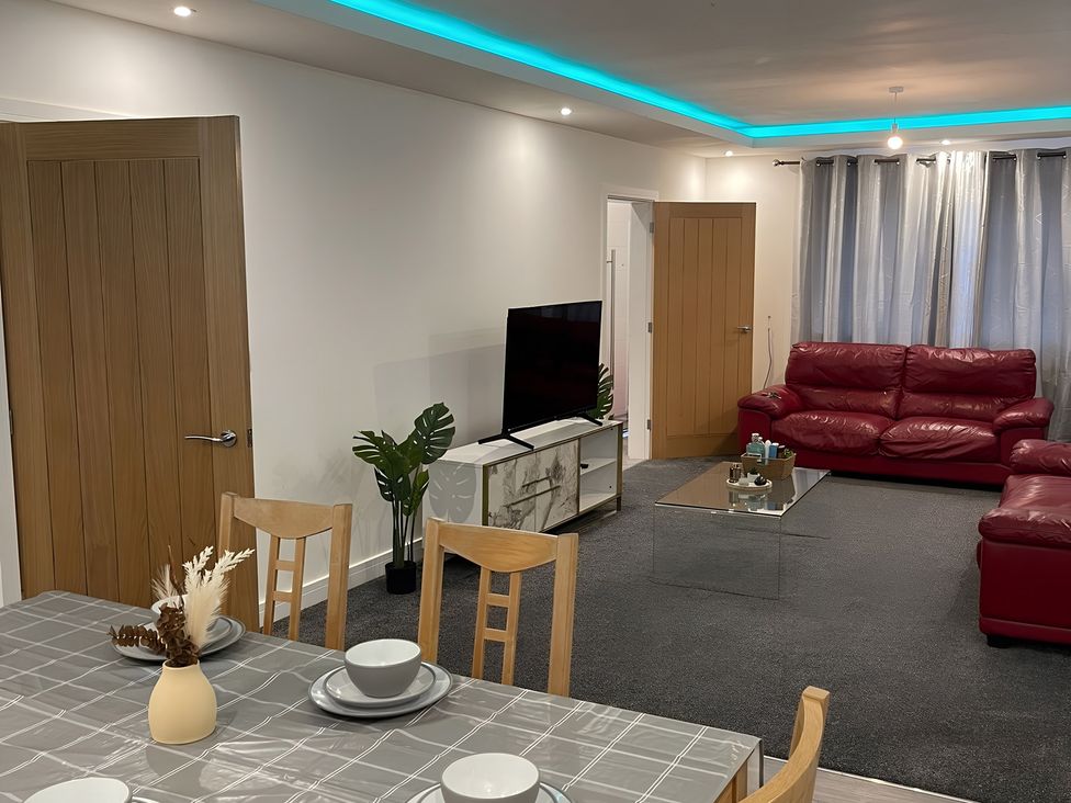 A living room with a sofa and television at Citrine Suite in Stoke-on-Trent