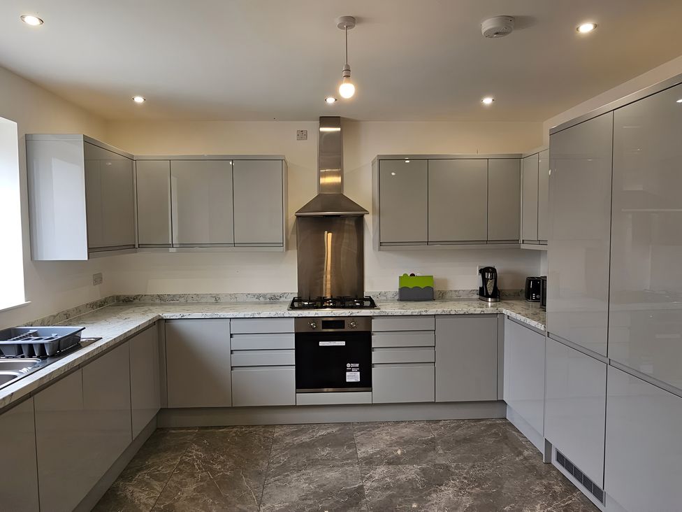 A kitchen with cabinets and appliances at Citrine Suite in Stoke-on-Trent