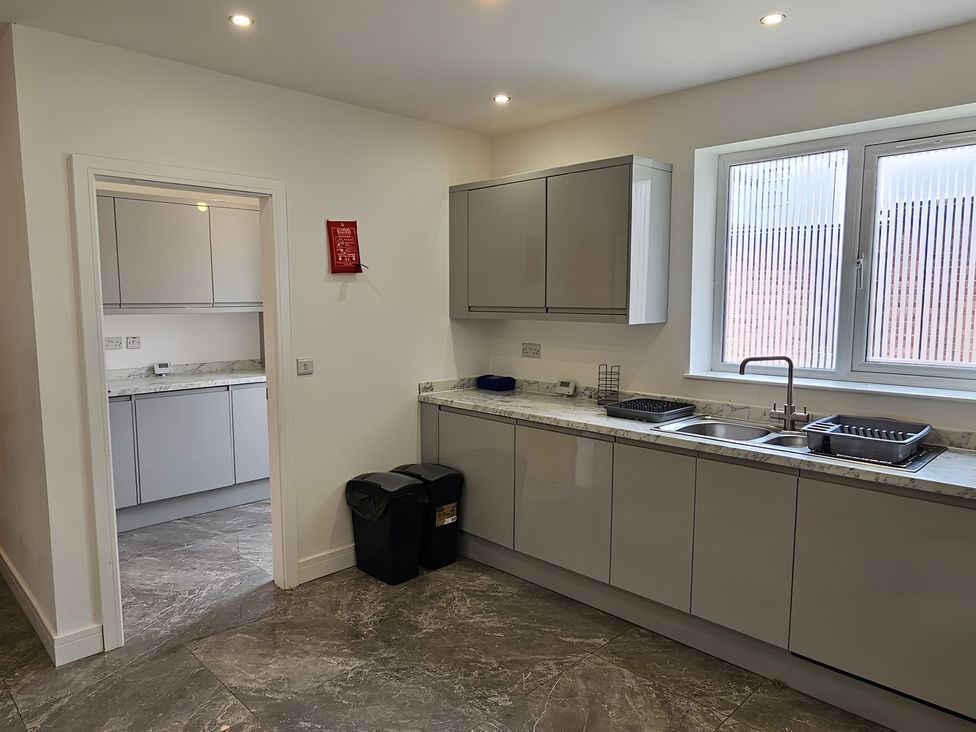 A kitchen with cabinets and a sink at Citrine Suite in Stoke-on-Trent