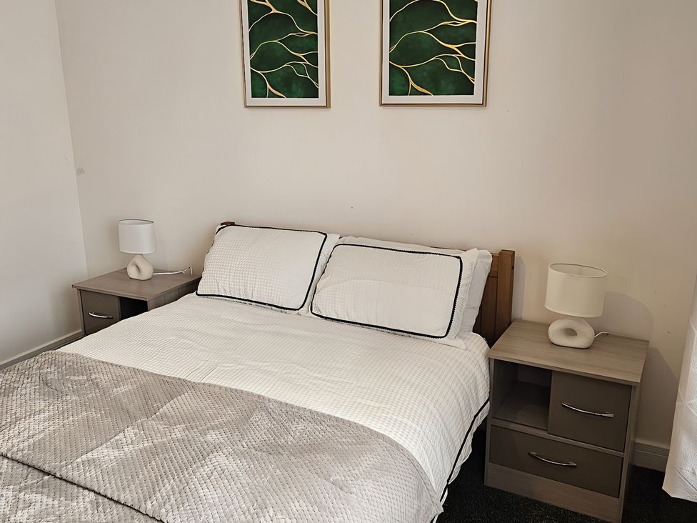 A bedroom with a bed and nightstands in Citrine Suite Stoke-on-Trent