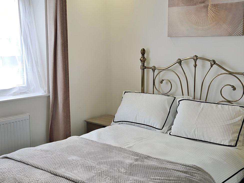 A bedroom with a bed and curtains at Citrine Suite in Stoke-on-Trent