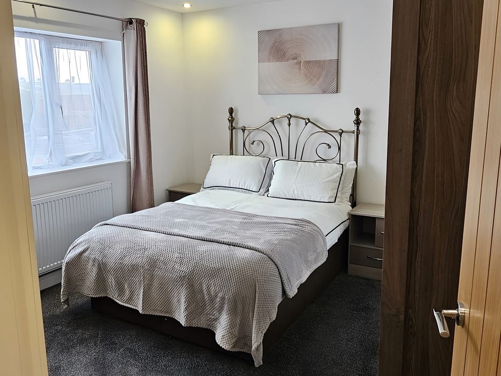 A bedroom with a bed and window at Citrine Suite in Stoke-on-Trent