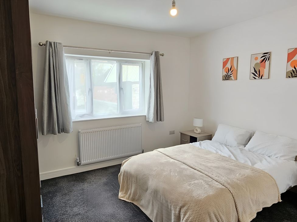 A bedroom with a bed and window at Citrine Suite in Stoke-on-Trent