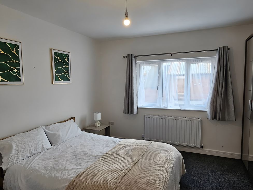 A bedroom with a bed and window at Citrine Suite in Stoke-on-Trent