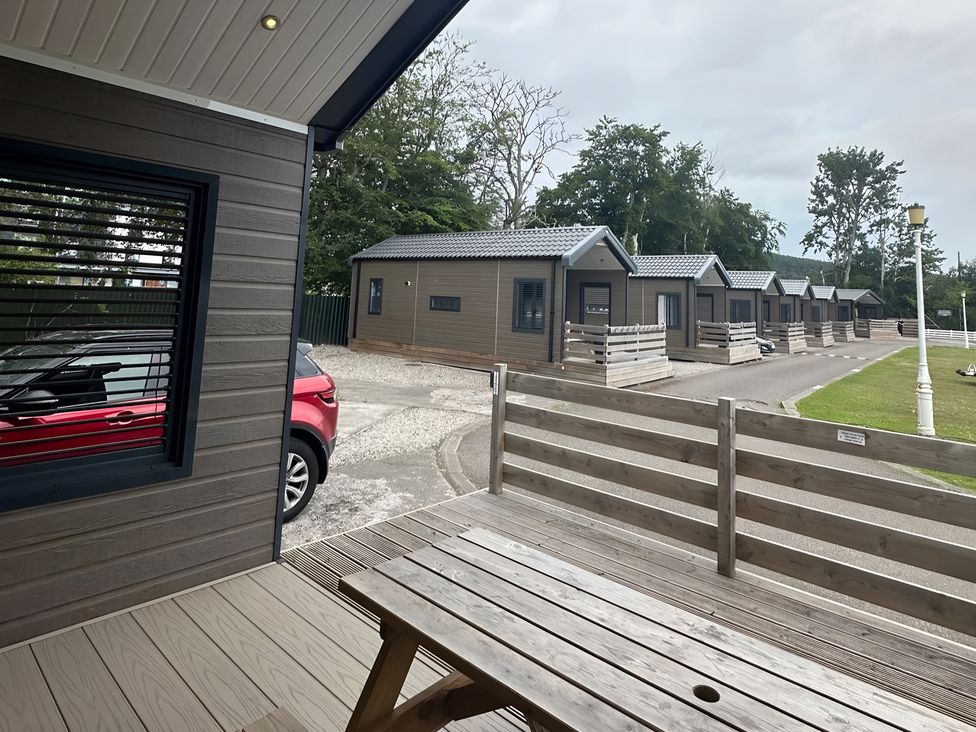 An outdoor area with cabins and a car at Inverness Lodge in Inverness