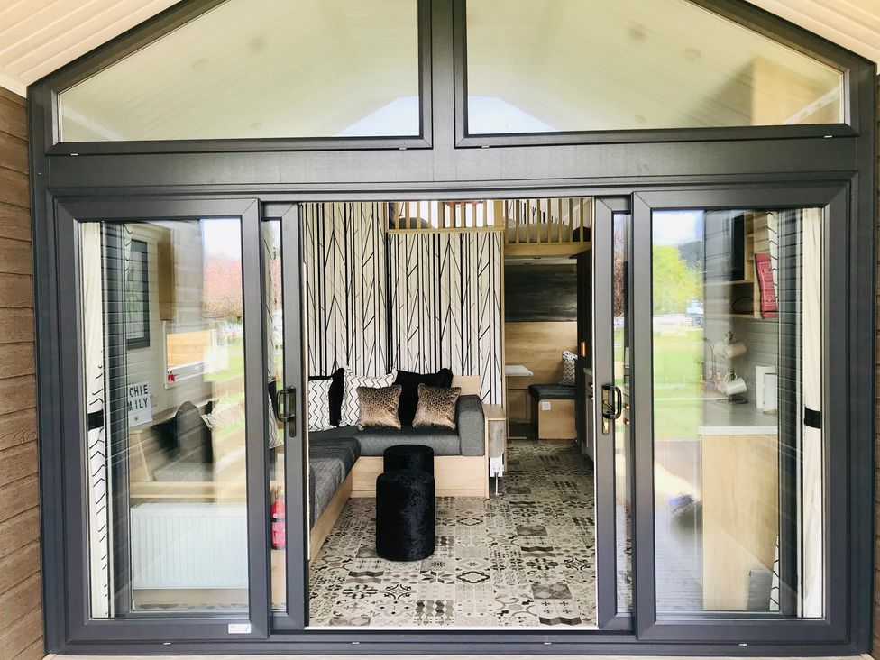 A living room with a sofa and table at Inverness Lodge in Inverness