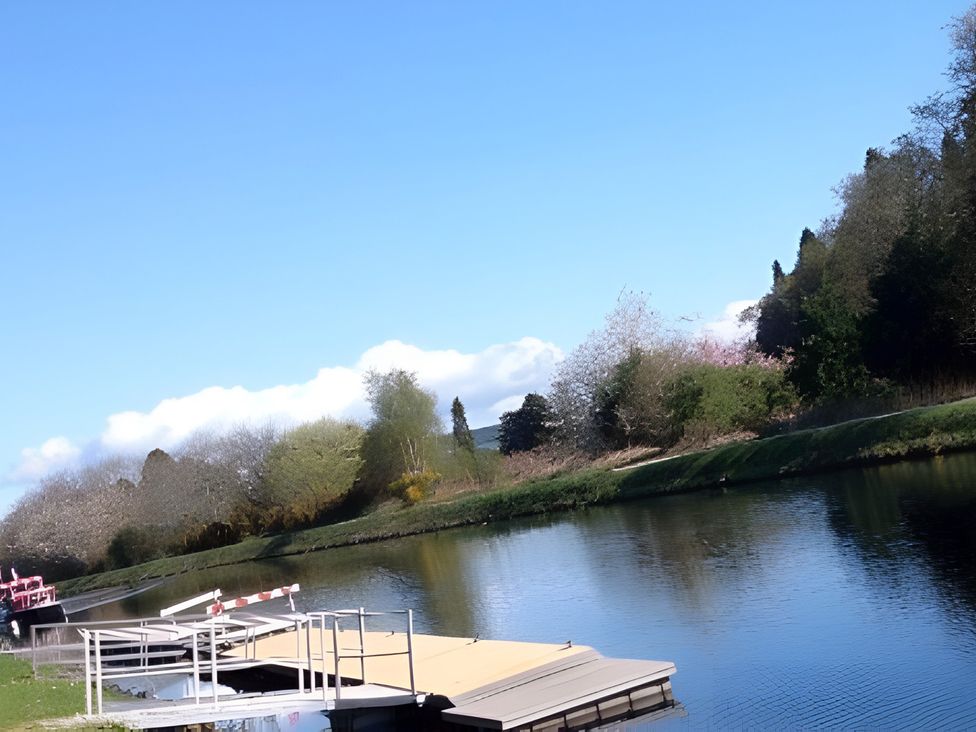 An outdoor view of a river with a dock and trees at Inverness Lodge in Inverness