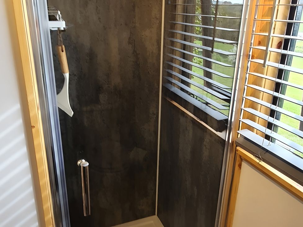 A shower with a window and blinds at Shepherds hut Dumfries