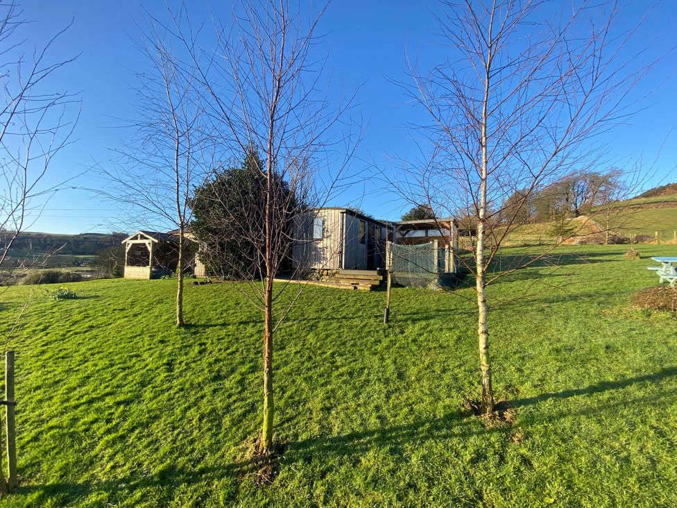 A garden with a shepherd's hut and gazebo at Shepherds hut Dumfries