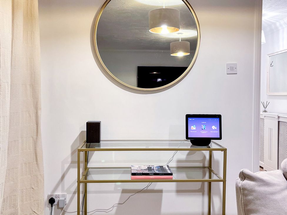 A living room with a mirror, a tablet, and a speaker at 1-Bed Apt in Rochester, Kent