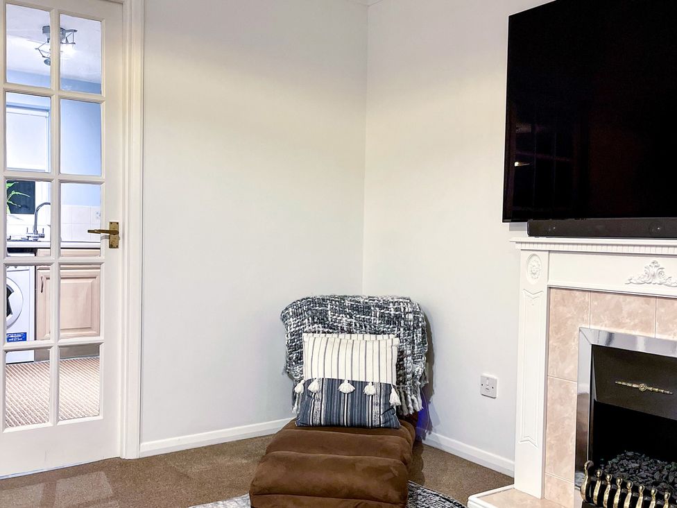 A living room with a television and a fireplace at 1-Bed Apt in Rochester, Kent
