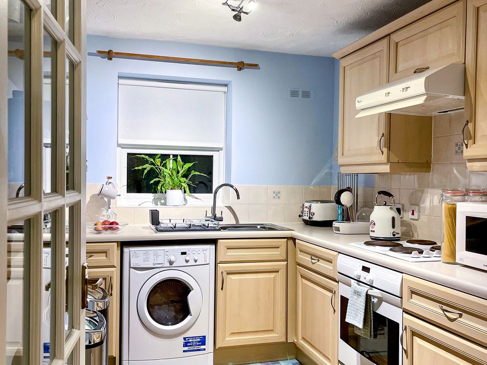 A kitchen with a washing machine and stove at 1-Bed Apt in Rochester, Kent