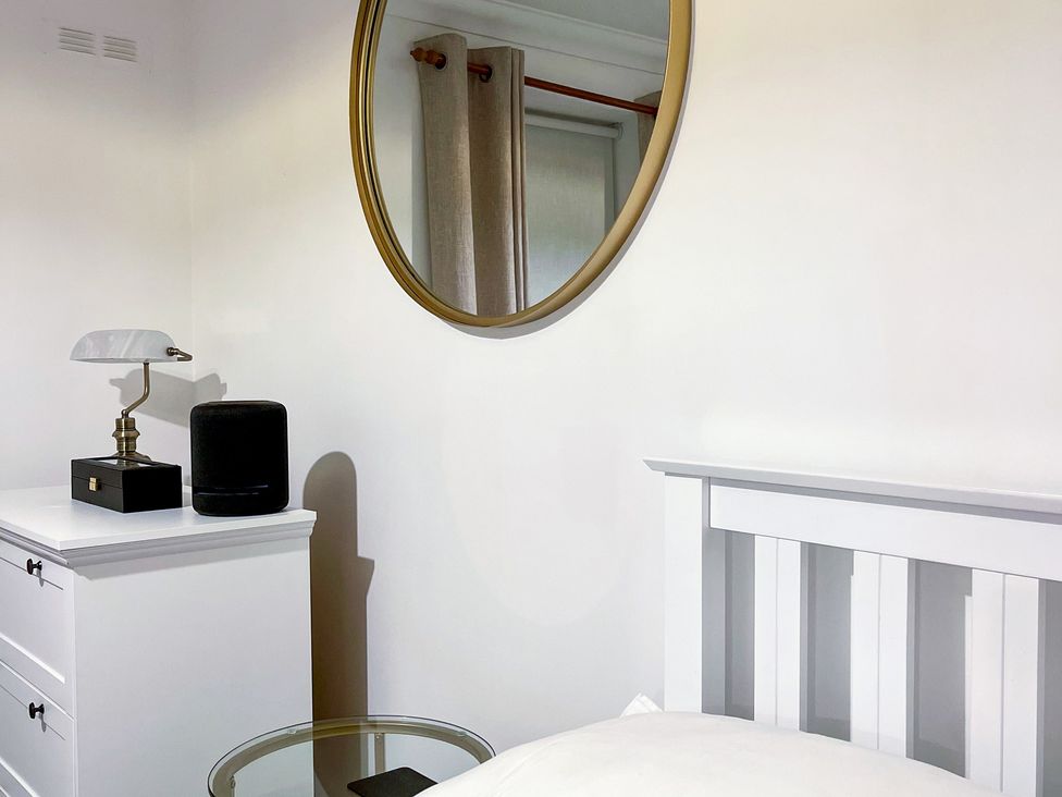 A bedroom with a lamp and a mirror at 1-Bed Apt in Rochester, Kent