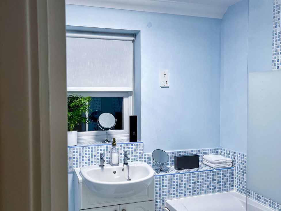 A bathroom with a sink, mirror, and towels at 1-Bed Apt in Rochester, Kent