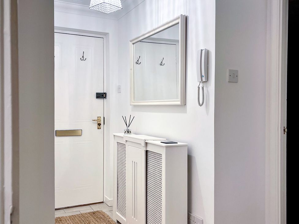 A hallway with a mirror and intercom at 1-Bed Apt in Rochester, Kent