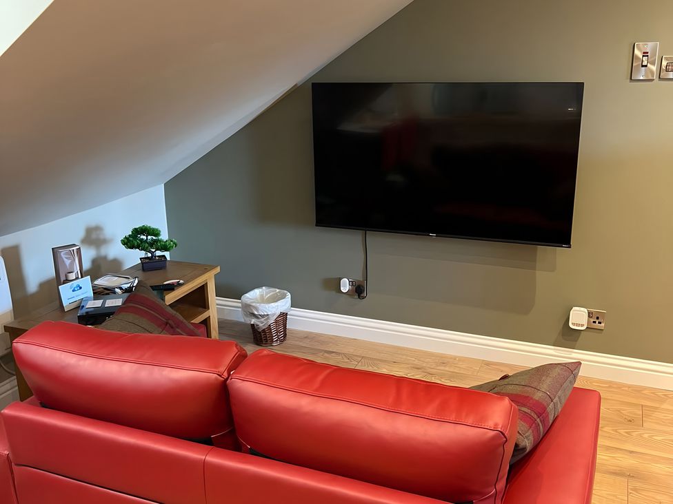 A living room with a television and sofa at 1 Bed Studio Pitlochry