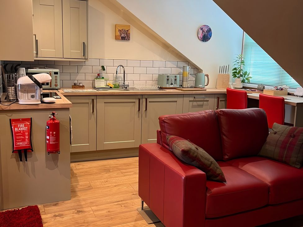 A kitchen with a sofa and appliances at 1 Bed Studio in Pitlochry