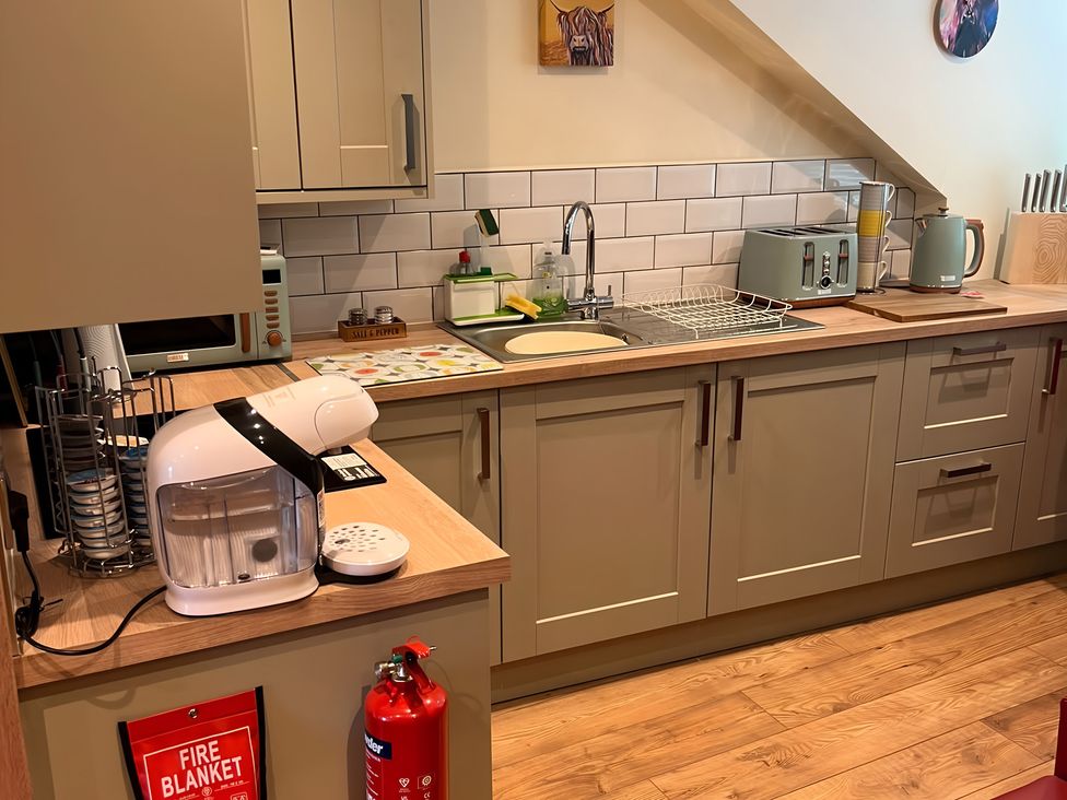 A kitchen with cabinets and appliances at 1 Bed Studio Pitlochry