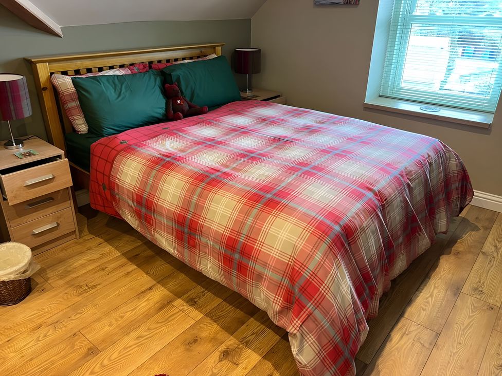 A bedroom with a bed and nightstand at 1 Bed Studio Pitlochry