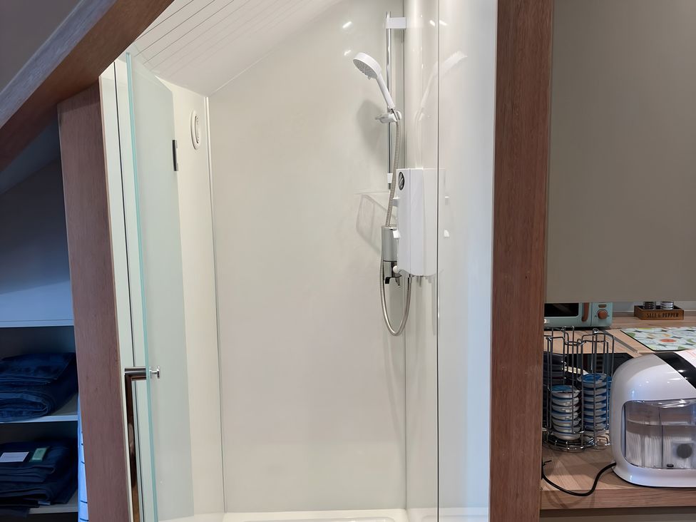 A shower area with a glass door at 1 Bed Studio in Pitlochry