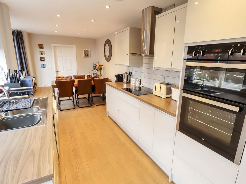 A kitchen with modern appliances and dining area at Love Lane Villa in Lincoln