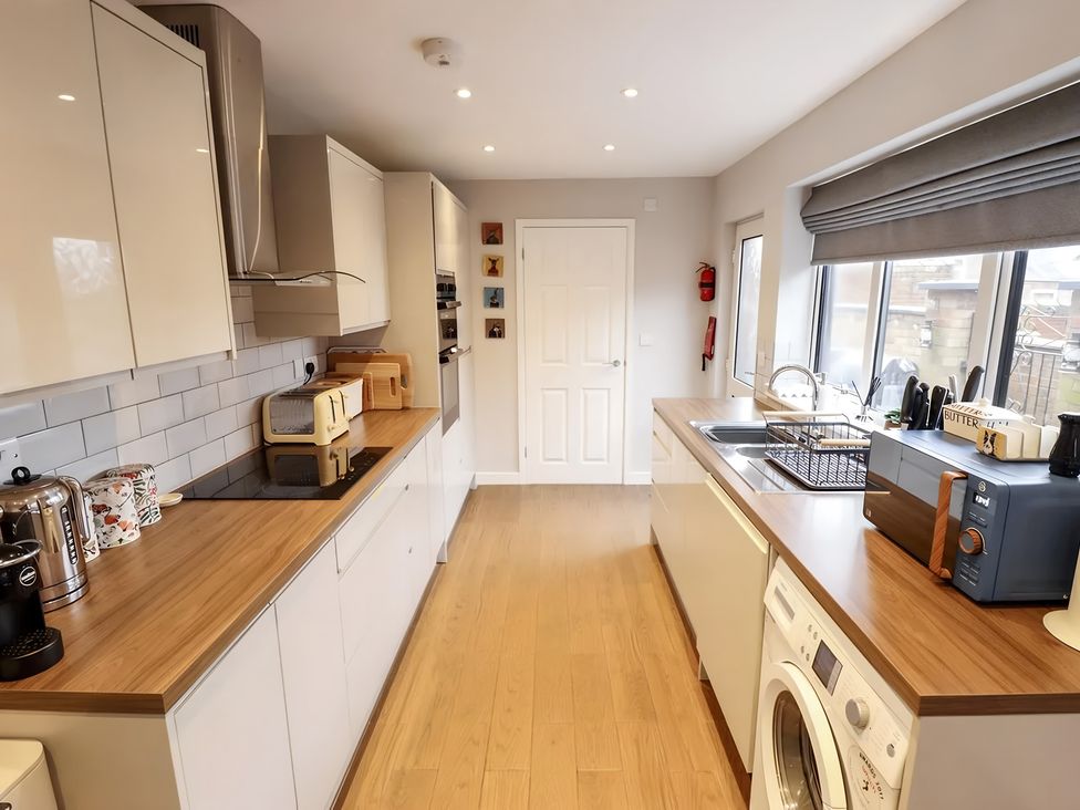 A kitchen with appliances and a door at Love Lane Villa in Lincoln