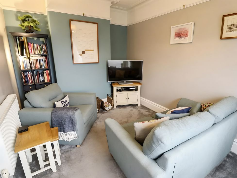 A living room with a television and bookshelf at Love Lane Villa in Lincoln
