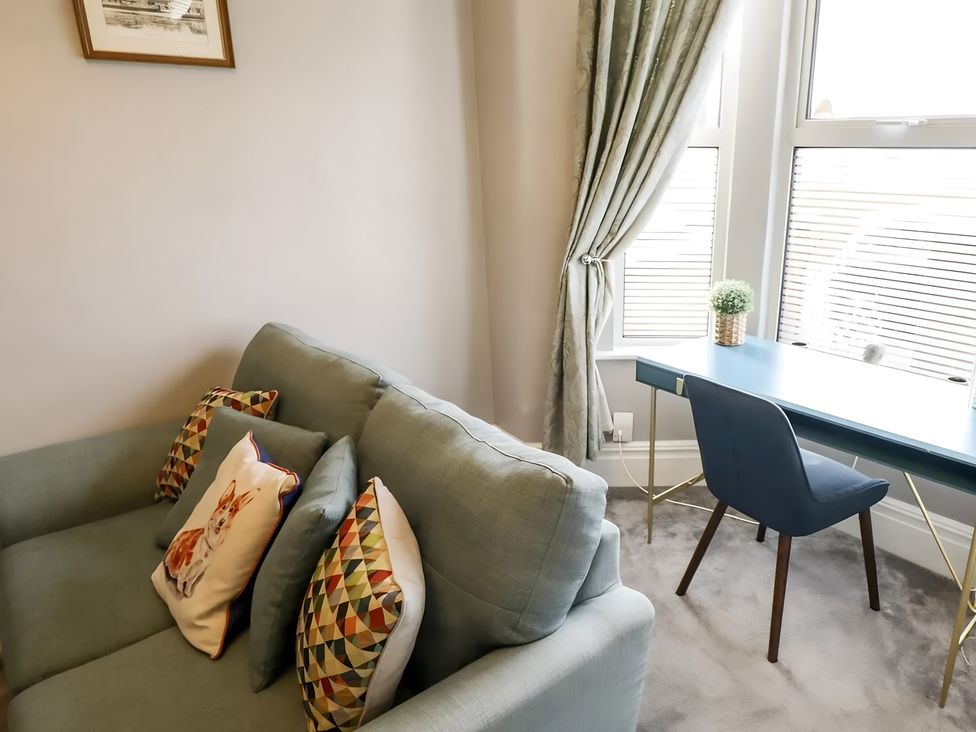 A living room with a sofa and desk at Love Lane Villa in Lincoln