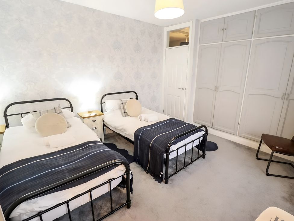 A bedroom with two beds and a wardrobe at Love Lane Villa in Lincoln