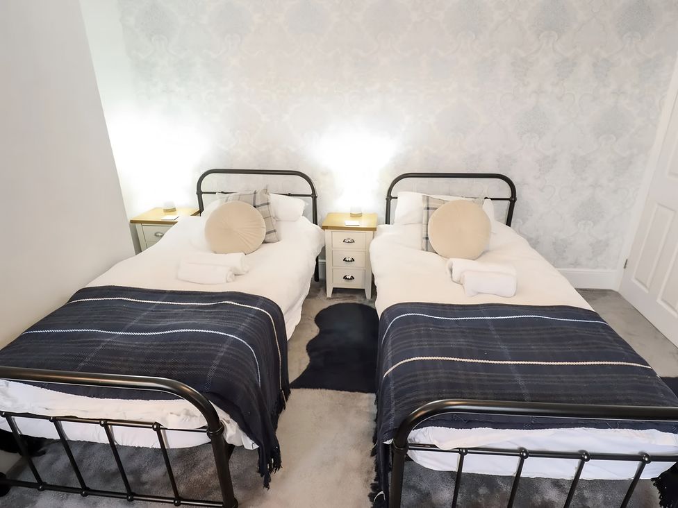 A bedroom with two single beds and bedside tables at Love Lane Villa in Lincoln