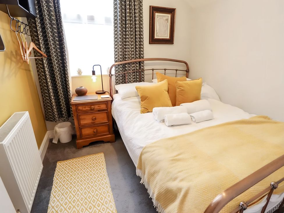 A bedroom with a bed and nightstand at Love Lane Villa, Lincoln