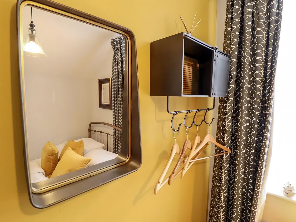 A bedroom with a mirror and clothing hangers at Love Lane Villa, Lincoln