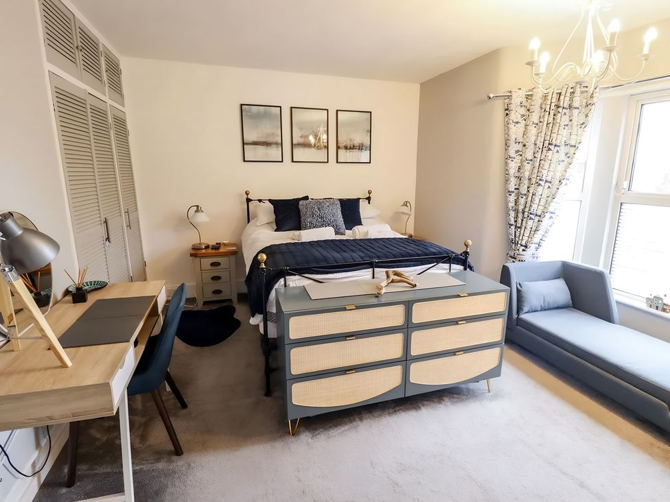 A bedroom with a bed, desk, and sofa at Love Lane Villa in Lincoln