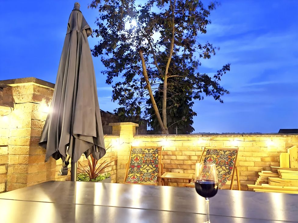 An outdoor space featuring an umbrella and chairs at Love Lane Villa in Lincoln