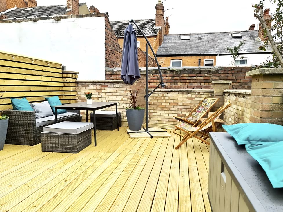 An outdoor terrace with furniture and planters at Love Lane Villa in Lincoln
