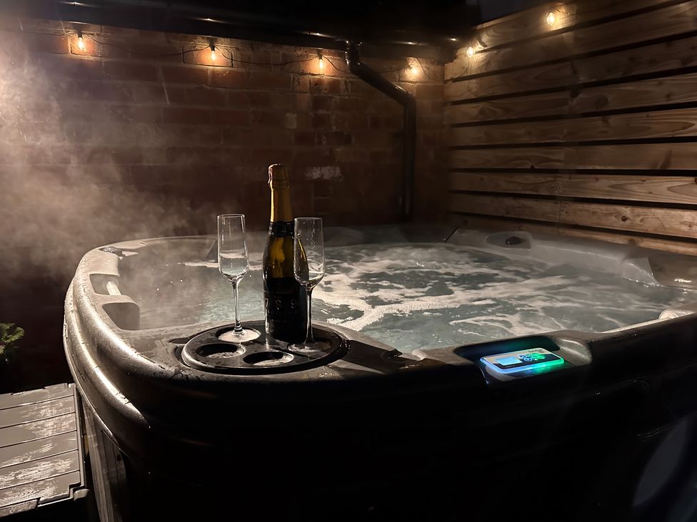 A hot tub with champagne and glasses at Love Lane Villa in Lincoln