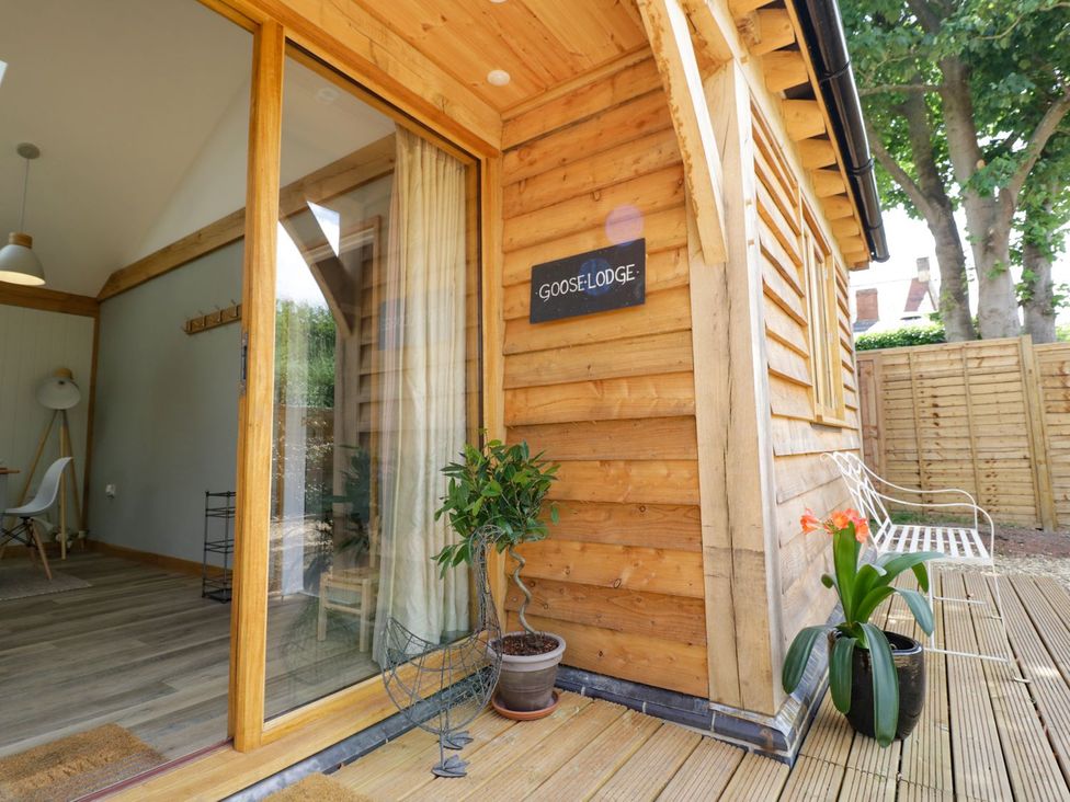 An outdoor area with wooden siding and a bench at Goose Lodge in Shipston-on-Stour