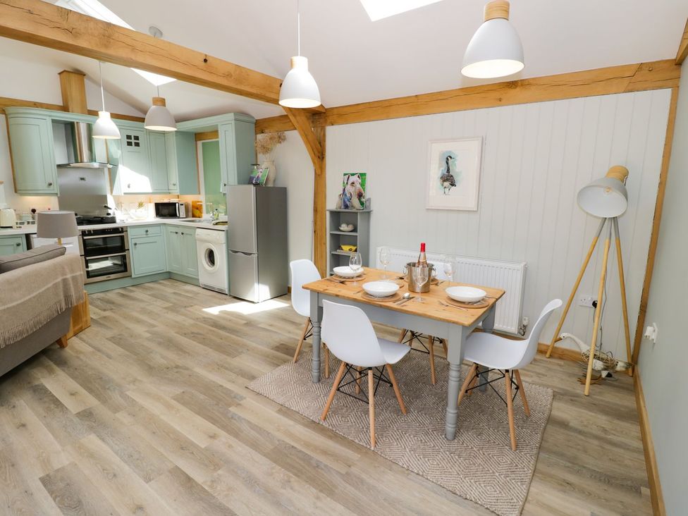 A kitchen and dining area with a dining table set for meals at Goose Lodge in Shipston-on-Stour