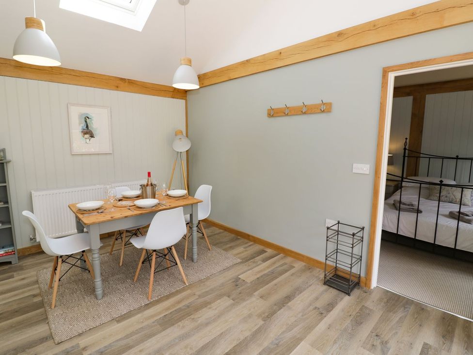 A dining room with a table and chairs at Goose Lodge in Shipston-on-Stour