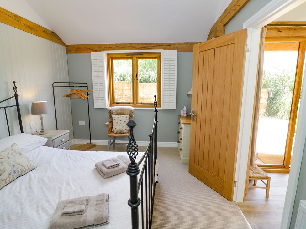 A bedroom with a bed and furniture at Goose Lodge in Shipston-on-Stour