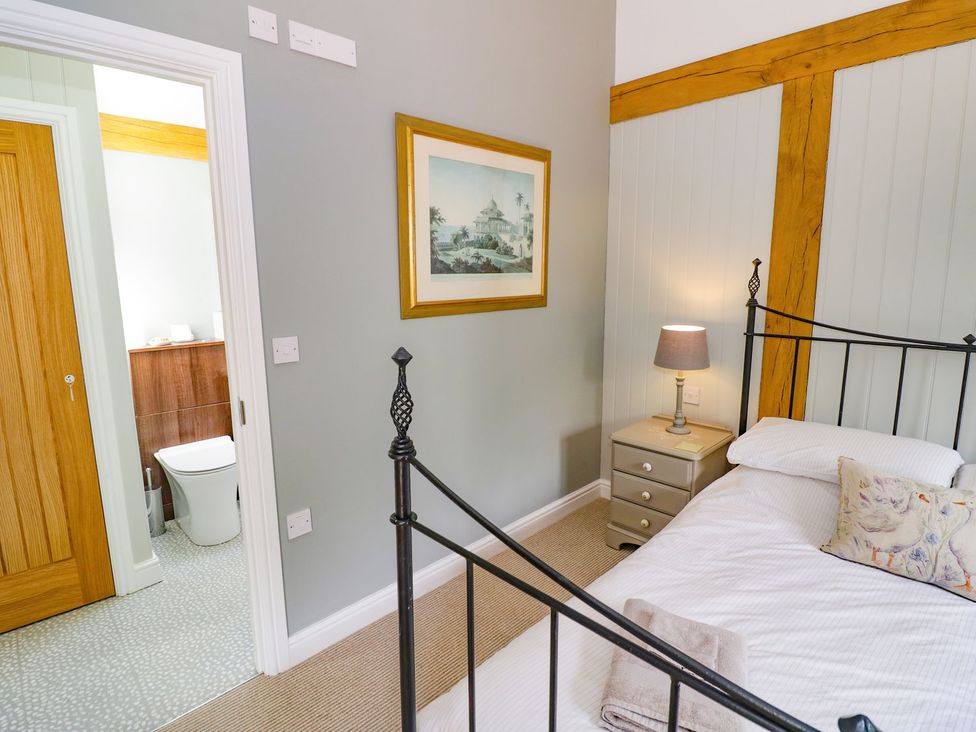 A bedroom with a bed and a lamp at Goose Lodge in Shipston-on-Stour