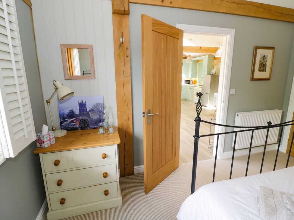 A bedroom with a dresser and mirror at Goose Lodge in Shipston-on-Stour