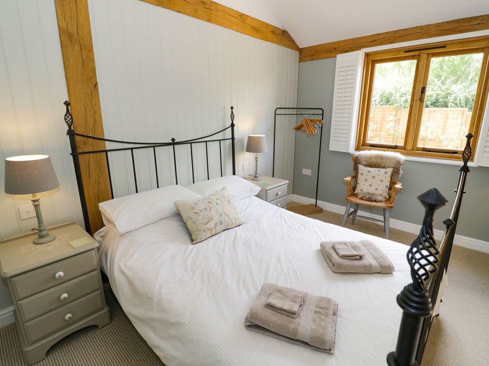 A bedroom with a bed and nightstand at Goose Lodge in Shipston-on-Stour