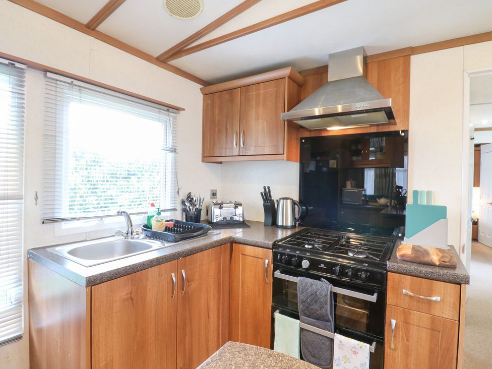 A kitchen with cabinets, stove, and sink at No 35 MP Billing Aquadrome Holiday Park