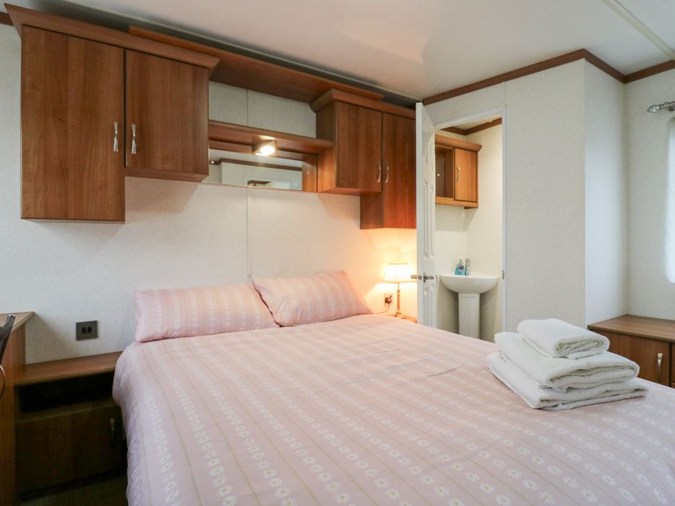 A bedroom with a bed and a bathroom sink at No 35 MP Billing Aquadrome Holiday Park