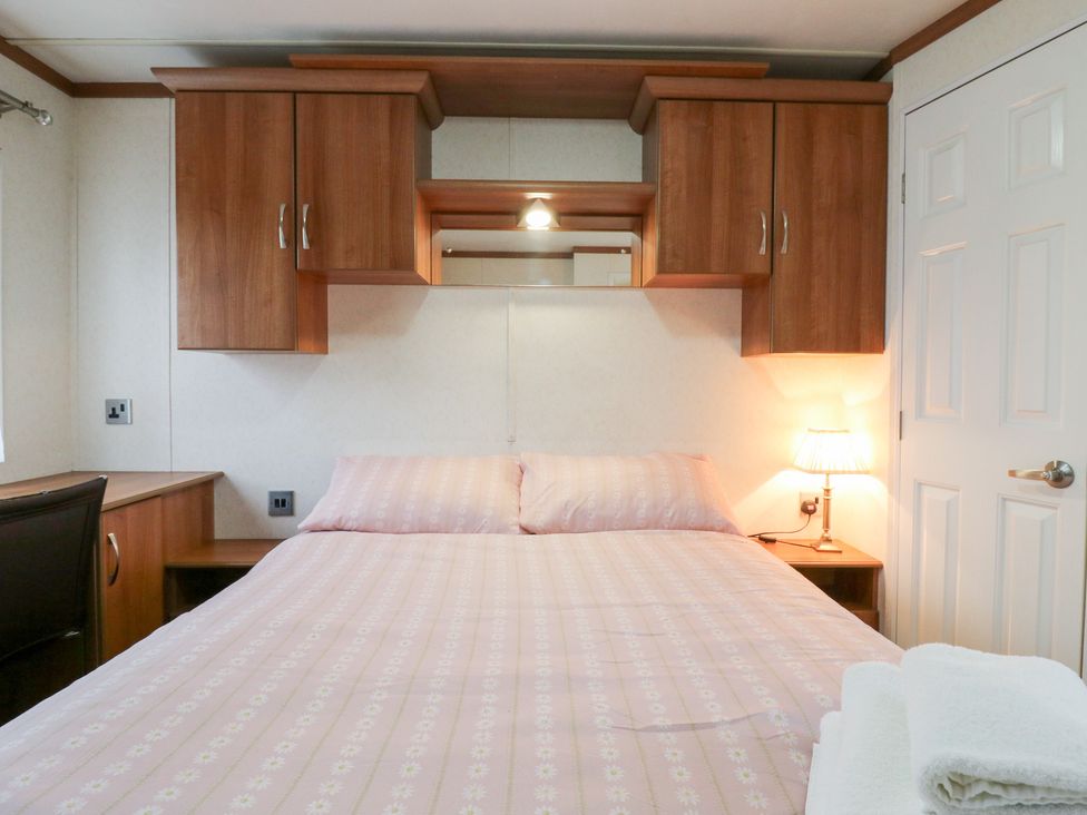 A bedroom with a bed and a bedside lamp at No 35 MP Billing Aquadrome Holiday Park