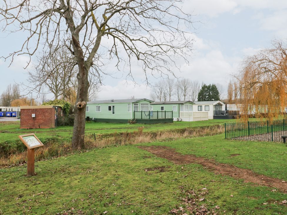 An outdoor view of holiday homes and a sign at No 35 MP Billing Aquadrome Holiday Park