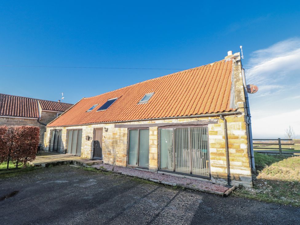 A house exterior with a red roof and windows at Millstone cottage in Whitby