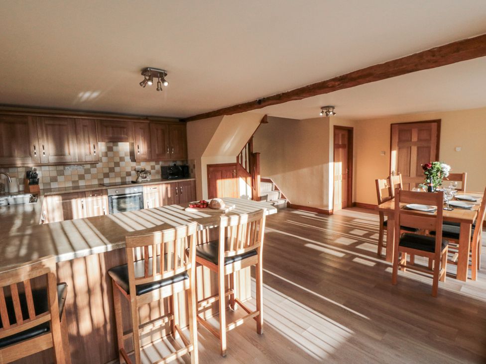 A kitchen with an island and dining table at Millstone Cottage Sneaton Thorpe near Whitby