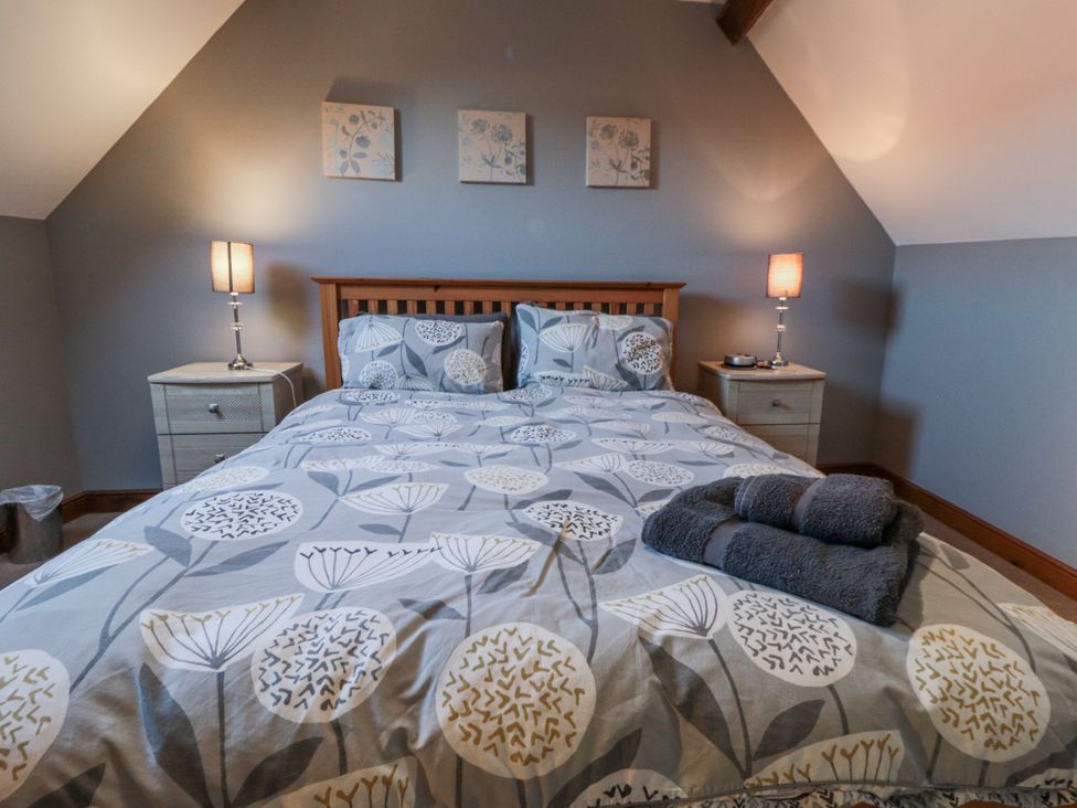 A bedroom with a bed and bedside tables at Millstone Cottage Sneaton Thorpe near Whitby